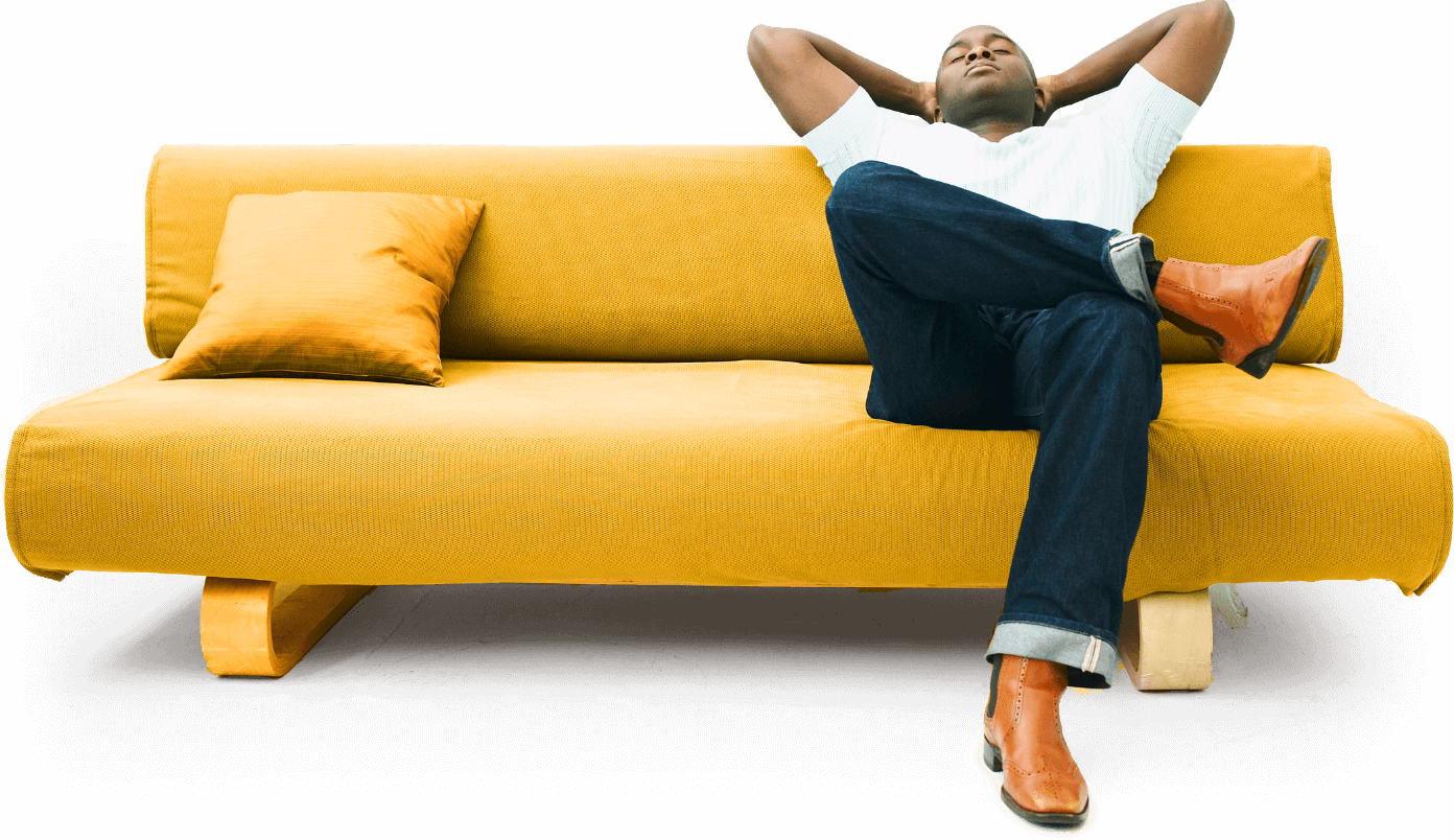 Man sitting with legs crossed on yellow couch