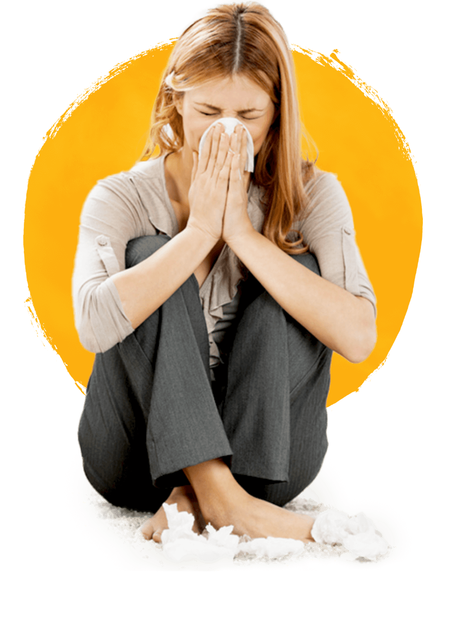 Young woman with sinusitis sitting on the ground blowing her nose surrounded by tissues