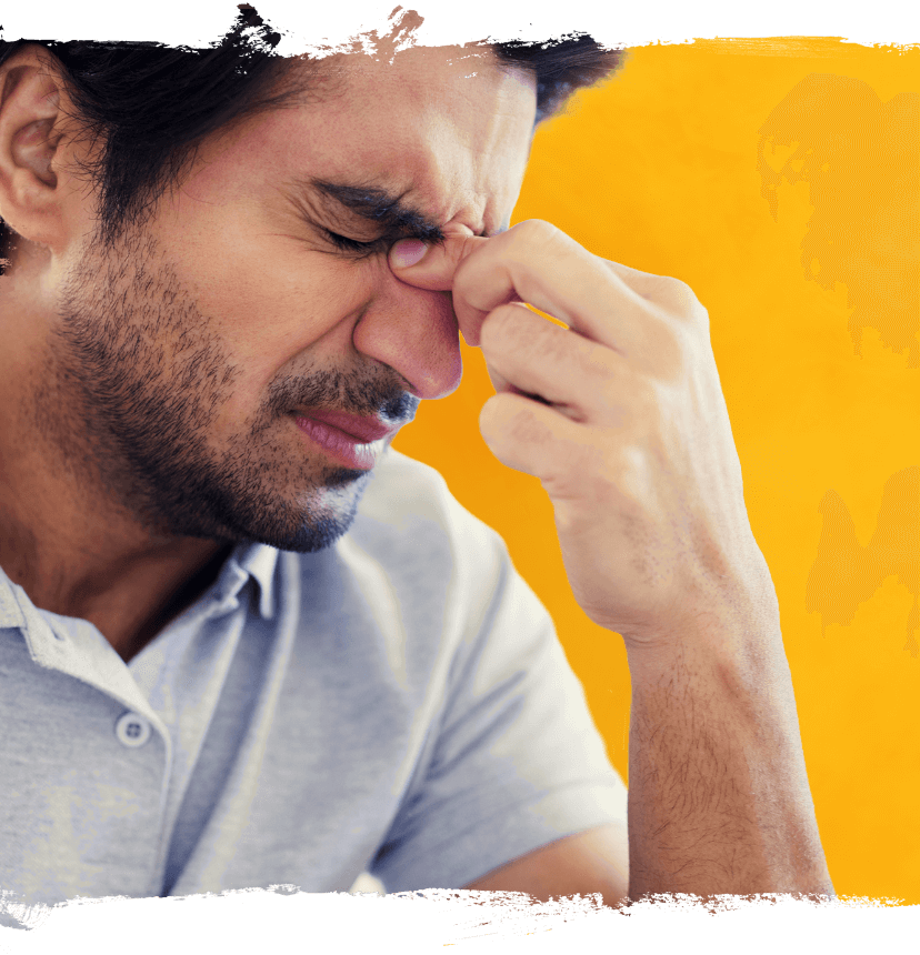 Young man holding the bridge of his nose suffering from chronic sinusitis, yellow background
